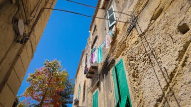 İtalya 'nın Tropea kentindeki bir ara sokakta çamaşır ipine asılmış geleneksel İtalyan mimarisinin cazibesini sergiliyor.