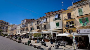 TROPEA, İTALYA - 2 Haziran 2025 - Tropea, İtalya 'da canlı bir cadde olan Corso Vittorio Emanuele, renkli binalar, dükkanlar, restoranlar ve hoş havanın keyfini çıkaran yerliler