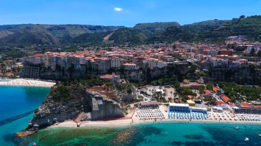 İtalya, Calabria 'da renkli binaları, kumlu plajları ve kristal berrak sularıyla Tyrhenian Denizi' ne bakan büyüleyici bir kasaba olan Tropea 'nın havadan görünüşü.