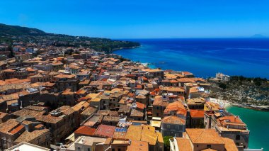 Tropea, Calabria 'nın karakteristik turuncu çatıları ve turkuaz Tyrhenian Denizi manzarası.