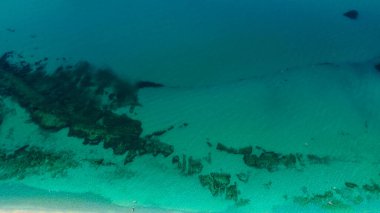 Güney İtalya, Calabria 'da bulunan, kristal berrak zümrüt yeşil su ve görünür kayalarla Tropea sahilinin nefes kesici hava manzarası.