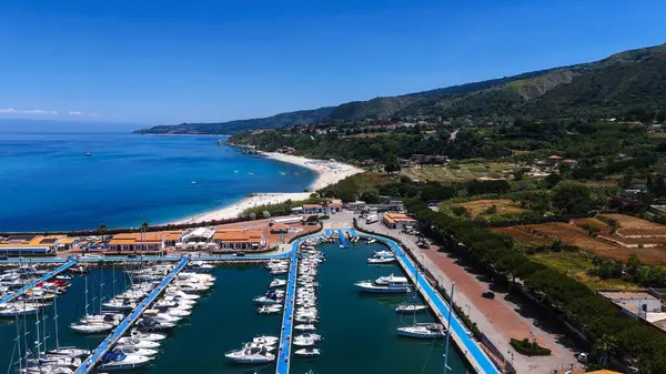 Güney İtalya, Calabria 'nın Tyrhenia sahilinde, rıhtımlı yatları ve güzel beyaz kumlu Tropea limanının hava manzarası.