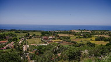 Güney İtalya, Calabria 'da arka planında Tyrhenian Denizi olan Zungri köyünün ekili tarlaları ve evleri