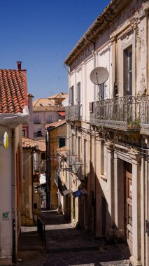 Güneşli bir yaz gününde Calabria, Pizzo 'da denize doğru inen dar bir caddeyi tanımlayan geleneksel mimari.