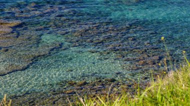 Pizzo, Calabria, İtalya 'da kayaları kaplayan şeffaf turkuaz su güzel ışık ve gölge desenleri oluşturur.