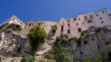 İtalya, Tropea 'da bir uçurumun tepesinde yükselen geleneksel evler, mimari ve doğanın eşsiz bir karışımını ön plana çıkarıyor.