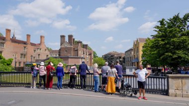 CAMBRIDGE, İngiltere - 11 Haziran 2025 - Güzel bir yaz gününde Cambridge Üniversitesi 'nin mimarisine hayran olan turistler
