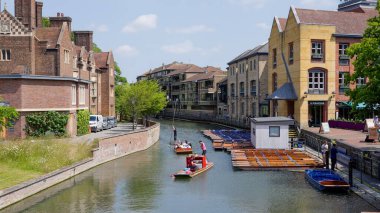 CAMBRIDGE, İngiltere - 11 Haziran 2025 - Cambridge 'deki River Cam' de yelken açan Punts, güneşli bir yaz gününde turlarının keyfini çıkarıyor.