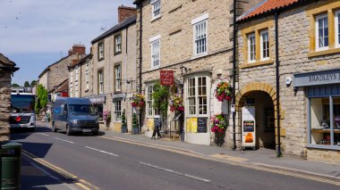 HELMSLEY, İngiltere - 12 Haziran 2025 - Güneşli bir günde Kuzey York Moors Ulusal Parkı 'ndaki pitoresk Helmsley köyünden geçen Amazon dağıtım aracı