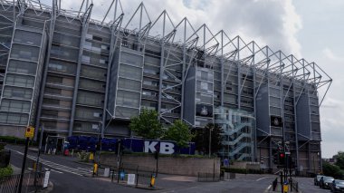 NEWCASTLE, İngiltere - 13 Haziran 2025 - St James 'Park' ın modern mimarisi, Newcastle United Stadyumu, Newcastle, İngiltere 'de bulutlu bir gökyüzüne karşı dimdik ayakta duruyor