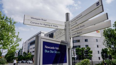 NEWCASTLE, UK - 13 Haziran 2025 - Westgate Yolu, Yaşlanma ve Canlılık Kampüsü, Discovery Museum ve Dance City gibi çeşitli yerlerin yönlerini gösteren birden fazla sokak işareti Tyne, İngiltere 'de Newcastle' da