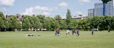 LEICESTER, İngiltere - 14 Haziran 2025 - Victoria Park, Leicester, İngiltere 'de güneşli bir günde voleybol oynayan bir grup öğrenci