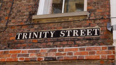 Cambridge, İngiltere 'de bir tuğla duvarda Trinity Street tabelası, tarihi ve ikonik bir sokak adı.
