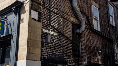 Newcastle şehir merkezinde Eldon Lane sokak tabelası, tuğla duvar, pencere ve havalandırma borusunu gösteriyor.