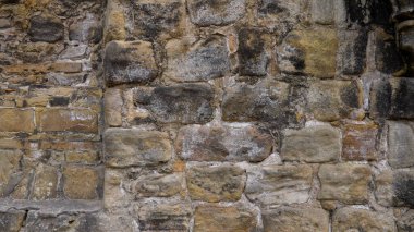 Değişik renkler ve dokular gösteren eskimiş taş duvar, arka plan ve yaratıcı projeler için mükemmel.