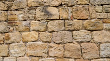 Eski bir duvar oluşturan yıpranmış kumtaşı blokları, tasarım projeleri için dokulu bir arkaplan yaratıyor