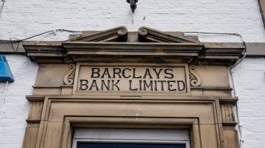 HELMSLEY, İngiltere - 12 Haziran 2025 - Kuzey York Moors Ulusal Parkı 'ndaki bir pazar kasabası olan Helmsley' de kumtaşı cephesine kazınmış tarihi Barclays Bank Limited tabelasının yakın çekimi