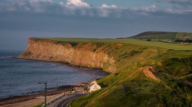 SALTBURN, İngiltere - 12 Haziran 2025 - Saltburn 'de Kuzey Denizi' ni karşılayan dramatik uçurumlar, altın saat ışığının sıcacık parıltısıyla yıkandı