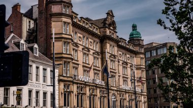 NEWCASTLE, İngiltere - 13 Haziran 2025 - İngiltere 'nin Tyne kentindeki Newcastle' daki tarihi County Hotel 'in düşük açılı görüntüsü, mimari ayrıntılarını ve şehir arkaplanını gözler önüne seriyor