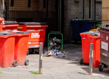 NEWCASTLE, İngiltere - 13 Haziran 2025 - Newcastle, İngiltere 'de bir caddeyi kirleten aşırı miktarda çöp kutusu ve çöp