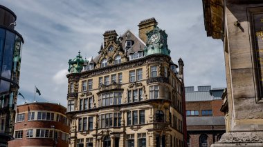 NEWCASTLE, İngiltere - 13 Haziran 2025 - Saat kulesinin yer aldığı dekoratif bir binanın düşük açılı görüntüsü, Newcastle 'ın mimari detaylarını ve Tyne üzerindeki kentsel manzarasını gözler önüne seriyor