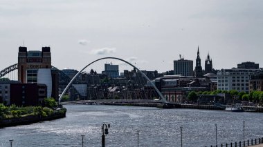 NEWCASTLE, İngiltere - 13 Haziran 2025 - Bulutlu bir günde Tyne Nehri 'ni kaplayan Milenyum Köprüsü ile Tyne şehir manzarası üzerine Newcastle