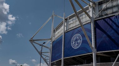 LEICESTER, İngiltere - 14 Haziran 2025 - King Power Stadyumu, Leicester City Futbol Kulübü 'nün evi, logosu güneşli bir günde mavi gökyüzü ve bulutlarla kaplı cephede sergilenmektedir.