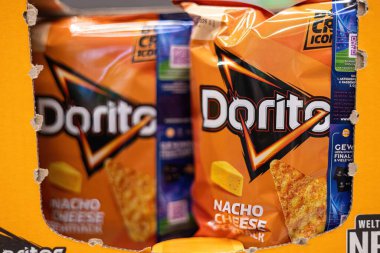 Bu resim, Doritos nacho peynirli atıştırmalık paketlerini perakende rafında belirgin bir şekilde sergiliyor, parlak ambalajlarını ve abur cubur aşıkları için karşı konulmaz çekiciliklerini sergiliyor. - FRANKFURT, Almanya - 21 Mart 2025