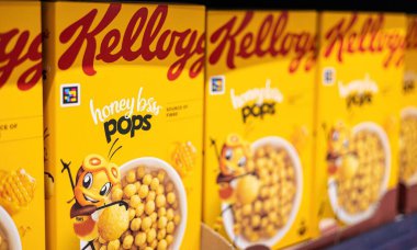 Kellog 'un ballı gevreğinden oluşan parlak ve neşeli bir kutu mısır gevreği, eğlenceli bir karakter tasarımı sergiliyor, keyifli bir kahvaltı deneyimi için enerji ve neşe somutlaştırıyor. - FRANKFURT, Almanya - 21 Mart 2025