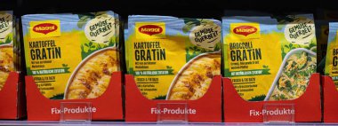 Aile yemeklerinde hızlı ve rahatlatıcı bir garnitür seçeneği olarak tasarlanmış Maggi patates graten paketlerinin cazibeli bir gösterisi. - FRANKFURT, Almanya - 21 Mart 2025