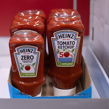 Heinz Domates Ketçapı 'nın çekici bir gösterisi, markanın ünlü ambalajını ve zengin rengini vurguluyor, her mutfak ve baharat koleksiyonu için mükemmel. - FRANKFURT, Almanya - 21 Mart 2025