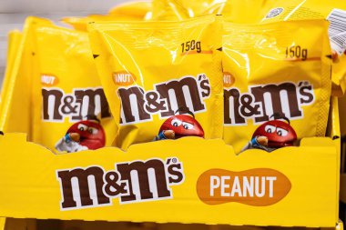 Fıstık MandM 'ler sergilenen parlak sarı ambalaj düzeneği, bu popüler, sevilen şeker şekerinin oyuncu karakterini ve markasını gözler önüne seriyor. - FRANKFURT, Almanya - 21 Mart 2025