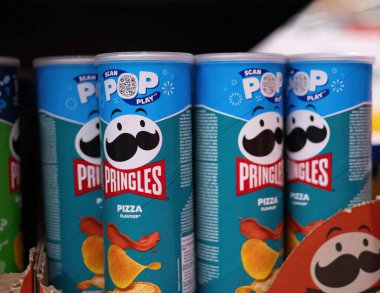 Raflarda sergilenen, eşsiz markalaşma ve canlı renklerin vurgulandığı çarpıcı bir Pringles Pizza çeşidi. - FRANKFURT, Almanya - 21 Mart 2025