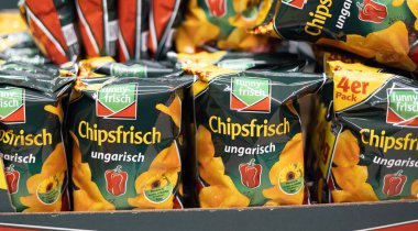 Canlı bir cips torbası gösterisi, farklı tatlar ve tasarımlar sergileniyor bir markette abur cubur aşıkları için. - FRANKFURT, Almanya - 21 Mart 2025