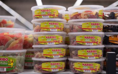 Renkli Haribo ekşi şekerleri açık kaplarda sergilenerek, tüketiciler için canlı cazibeleri ve neşeli şekilleri vurgulanıyor. - FRANKFURT, Almanya - 21 Mart 2025