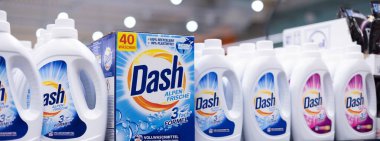 Bu resim çarpıcı bir şekilde düzenlenmiş Dash çamaşır deterjanı şişelerini tasvir ediyor, temizliği ve ev bakımını vurguluyor. - FRANKFURT, Almanya - 21 Mart 2025