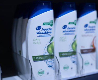 Kafa ve Omuz şampuan şişelerinden oluşan düzgün bir sıra, sağlıklı bir kafa derisi ve parlak saçlar için kepek önleyici faydaları vurguluyor. - FRANKFURT, Almanya - 21 Mart 2025