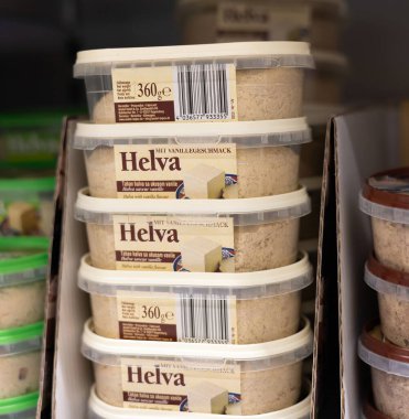Bu resimde birden fazla helva konteynırı sergileniyor, tatlı bir tatlı, perakende satış ortamında düzgünce istiflenmiş, cazibelerini vurguluyor. - FRANKFURT, Almanya - 21 Mart 2025
