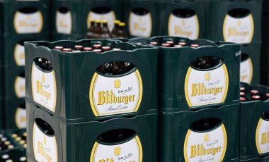 Düzenli bir Bitburger bira şişesi yığını. Perakende satış ortamında geleneksel yeşil ambalajlar sergileniyor. - FRANKFURT, Almanya - 21 Mart 2025