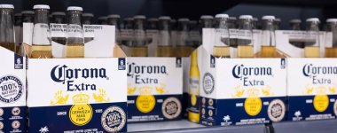 Altılı paket Corona Extra şişesi, markanın ikonik tasarımı ve plaj kenarı rahatlama deneyimi sergileniyor. - FRANKFURT, Almanya - 21 Mart 2025