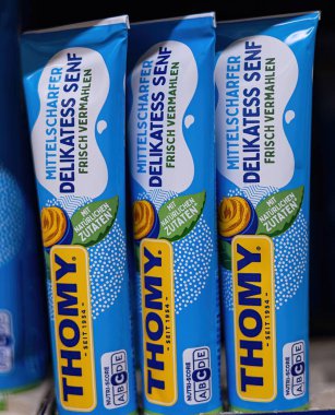 Bu orta sıcak Thomy hardal tüpleri izleyicilerin dikkatini canlı tasarımlarıyla çeker ve klasik yemek ve yemeklere lezzet katma vaadinde bulunur. - FRANKFURT, Almanya - 21 Mart 2025