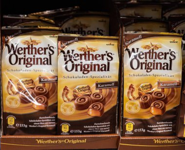 Werther 'in orijinal karamel şekerlerinin her yerdeki karamel sevenlere hitap eden klasik paketlerinin sergilendiği sıcak bir gösteri. - FRANKFURT, Almanya - 21 Mart 2025
