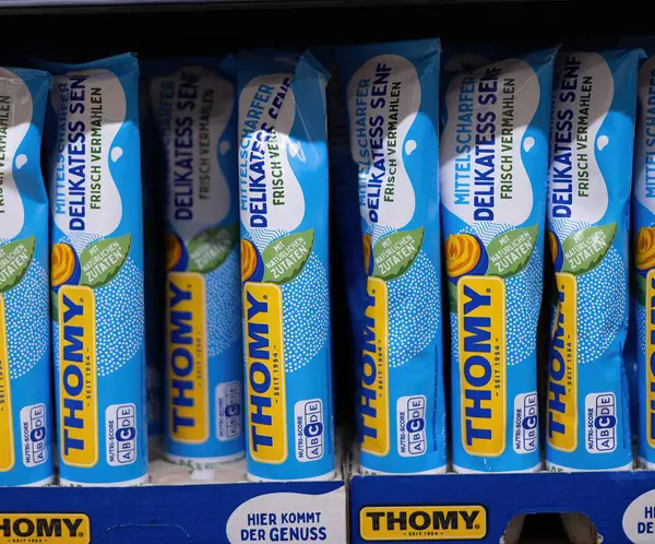 Thomy hardal tüplerinin göz alıcı mavi ambalajı aşçılık tutkunları ve baharat severler için cazip lezzetlerini ve kremsi dokularını vurguluyor. - FRANKFURT, Almanya - 21 Mart 2025