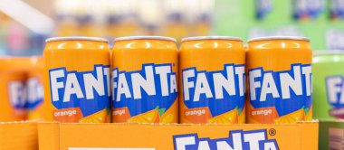 Bir perakende mağazasında canlı renkler ve marka kimliğiyle düzgünce istiflenmiş Fanta portakallı soda kutularının çekici bir gösterisi. - FRANKFURT, Almanya - 21 Mart 2025