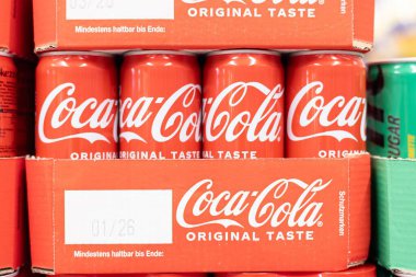 Coca-Cola kutularının düzenli bir şekilde sergilenmesi, ikonik markayı ve tanınabilir ambalajını bir pazarda sergilemek. - FRANKFURT, Almanya - 21 Mart 2025
