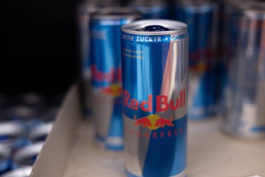 Kullanışlı bir ekrana istiflenmiş, kendine özgü mavi ve gümüş tasarımını vurgulayan bir Red Bull enerji içeceği kutusu koleksiyonu. - FRANKFURT, Almanya - 21 Mart 2025