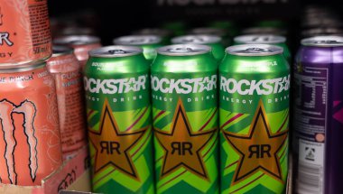 Rockstar ekşi elma suyu kutularının canlı bir görüntüsü ürünün dinamik tasarımı ve enerjik markalaşmasını vurguluyor. - FRANKFURT, Almanya - 21 Mart 2025