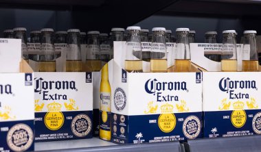 Altılı paket Corona Extra şişesi, markanın ikonik tasarımı ve plaj kenarı rahatlama deneyimi sergileniyor. - FRANKFURT, Almanya - 21 Mart 2025