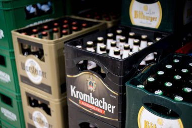 Krombacher bira kasalarının canlı bir düzenlemesi, diğer çeşitleri arasında popüler markaların alkolsüz seçenekleri sergileniyor. - FRANKFURT, Almanya - 21 Mart 2025