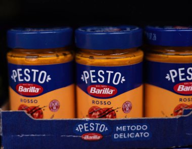 Barilla pesto sosu kavanozlarının düzenli bir düzenlemesi, taze malzemeler ve canlı renkler sergilenmesi, çeşitli yemekleri zengin ve aromatik tatlarla geliştirmek için mükemmel. - FRANKFURT, Almanya - 21 Mart 2025